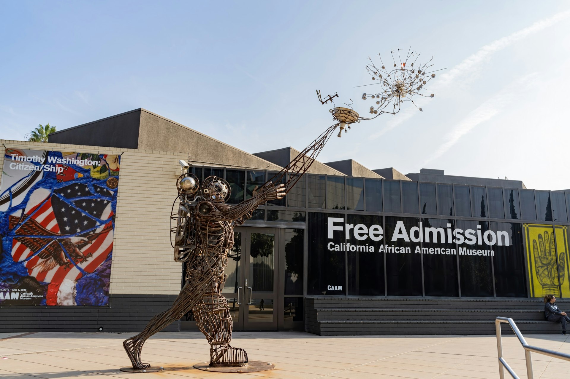 A large wire statue in the form of an astronaut releasing something into the air